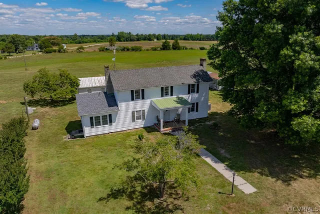 an aerial view of a house with a yard and lake view