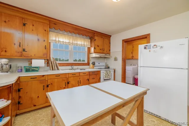 a kitchen with a refrigerator a stove top oven and a sink