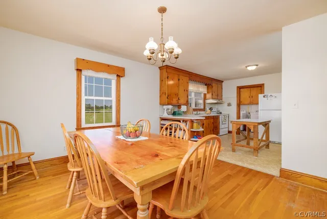 a dining room with furniture a chandelier and wooden floor
