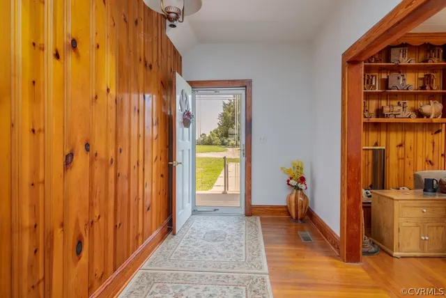 a view of a hallway with wooden floor and entryway