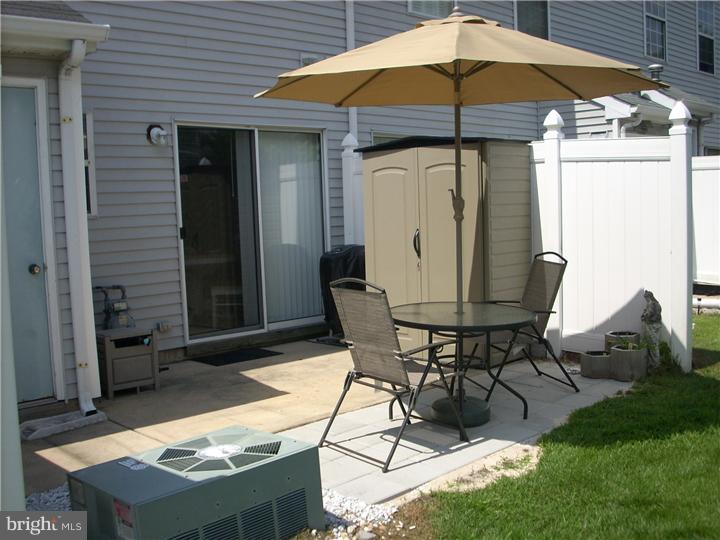 711 Rutland Court Sewell, NJ 08080 - Photo 14 of 18 a view of a patio with table and chairs under an umbrella