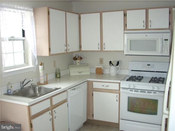 711 Rutland Court Sewell, NJ 08080 - Photo 6 of 18 a kitchen with white cabinets sink and appliances