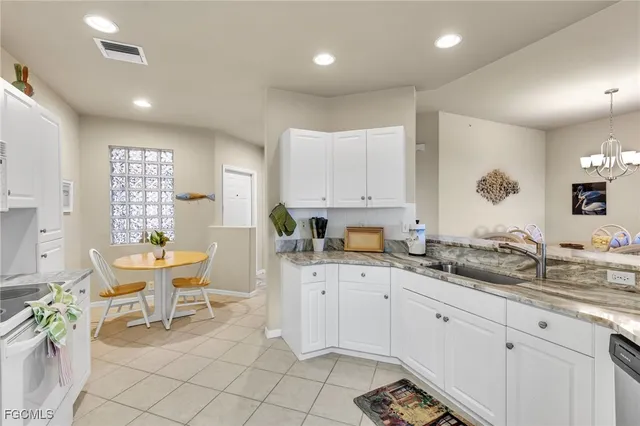 a kitchen with a sink and chairs