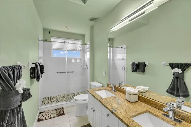 a bathroom with a granite countertop toilet sink and mirror