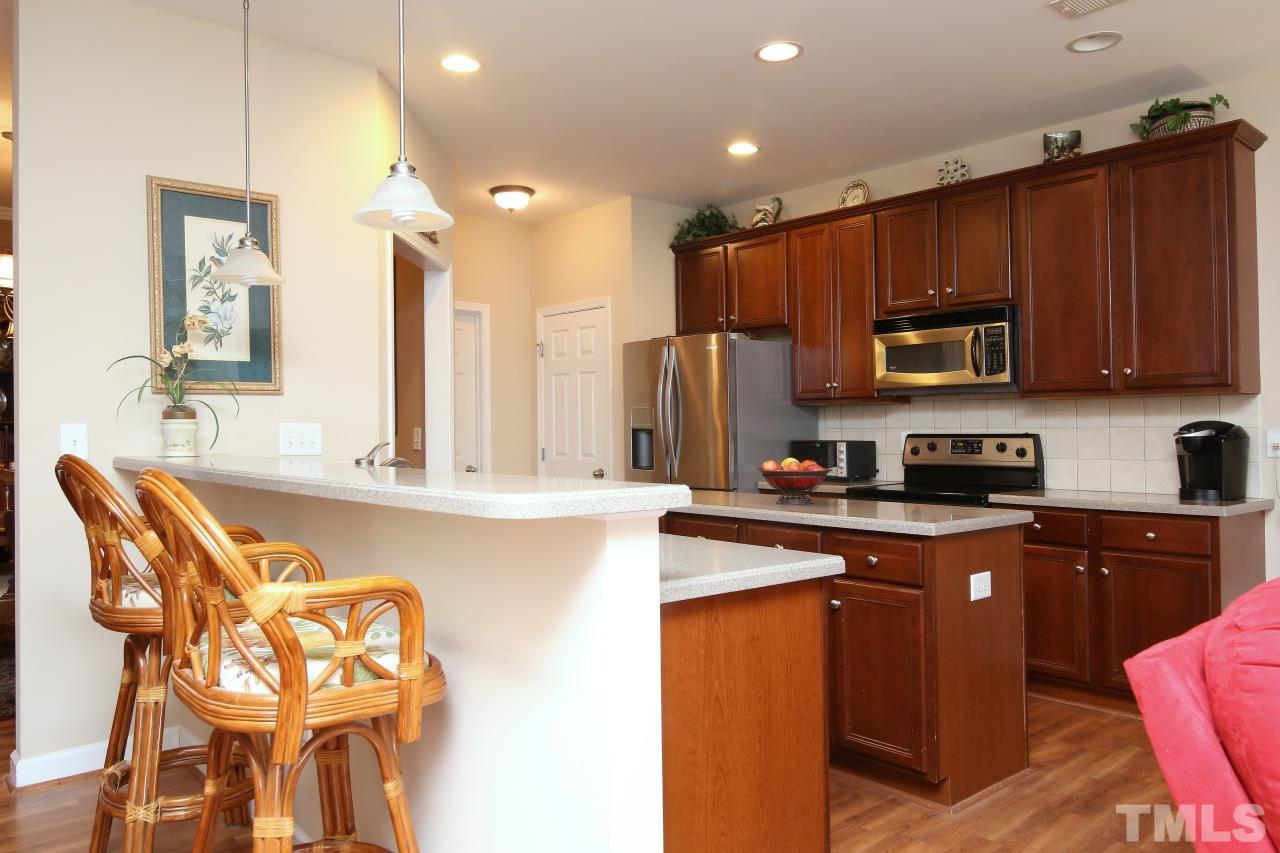 12302 Mossgreen Street Raleigh, NC 27614 - Photo 7 of 25 The kitchen features an eat in bar top, large island, solid surface counter tops, stainless steel appliances and a separate pantry.