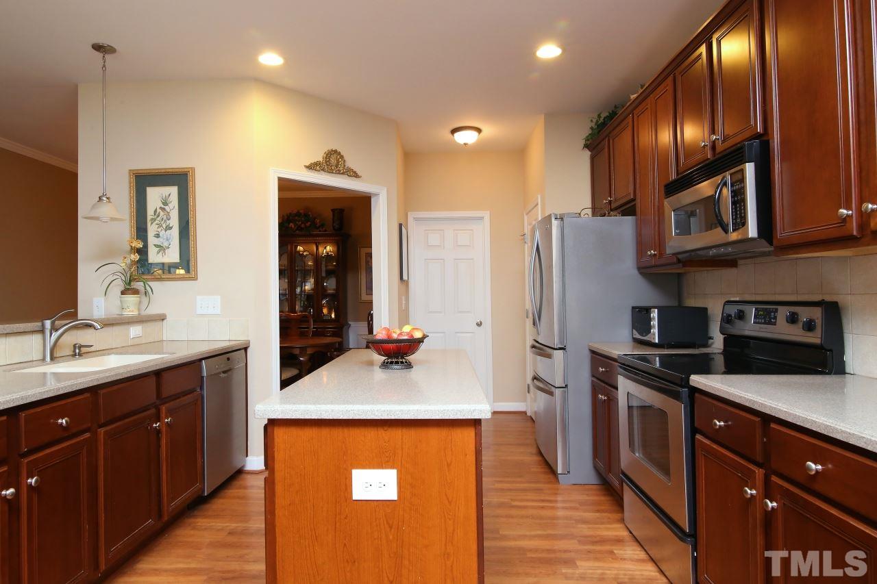 12302 Mossgreen Street Raleigh, NC 27614 - Photo 8 of 25 The kitchen features an eat in bar top, large island, solid surface counter tops, stainless steel appliances and a separate pantry.