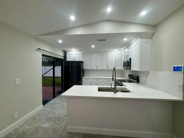 a large kitchen with stainless steel appliances a large counter top