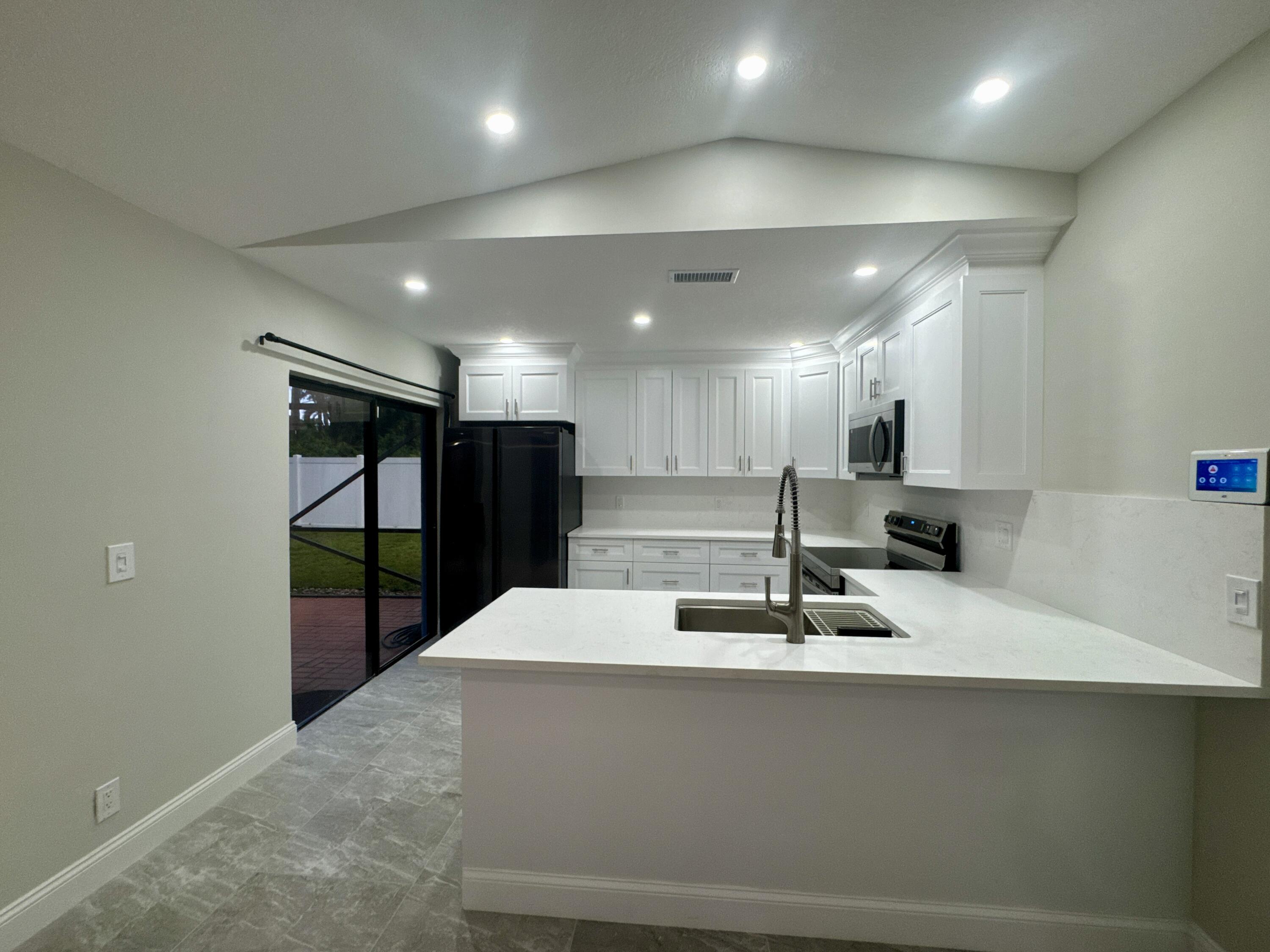 4160 Northwest 7th Court Delray Beach, FL 33445 - Photo 11 of 46 a large kitchen with stainless steel appliances a large counter top