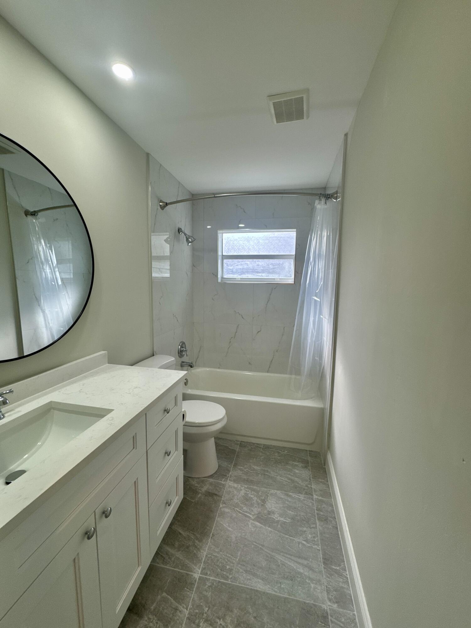 4160 Northwest 7th Court Delray Beach, FL 33445 - Photo 28 of 46 a bathroom with a granite countertop sink toilet a mirror and bathtub