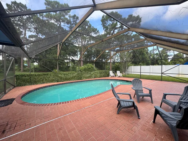 a view of a swimming pool with a patio and dining room