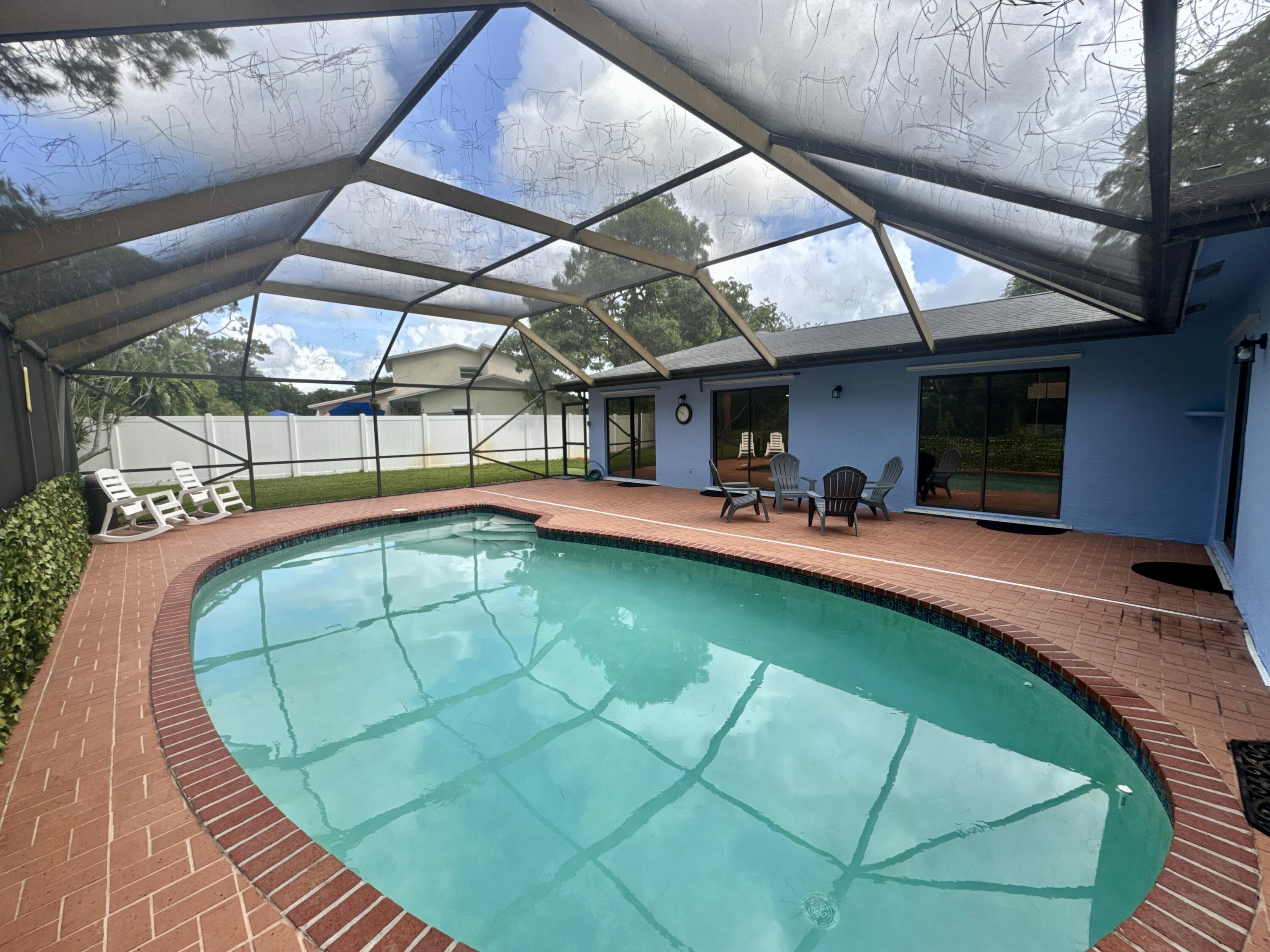 4160 Northwest 7th Court Delray Beach, FL 33445 - Photo 32 of 46 a view of a swimming pool with a patio and dining room