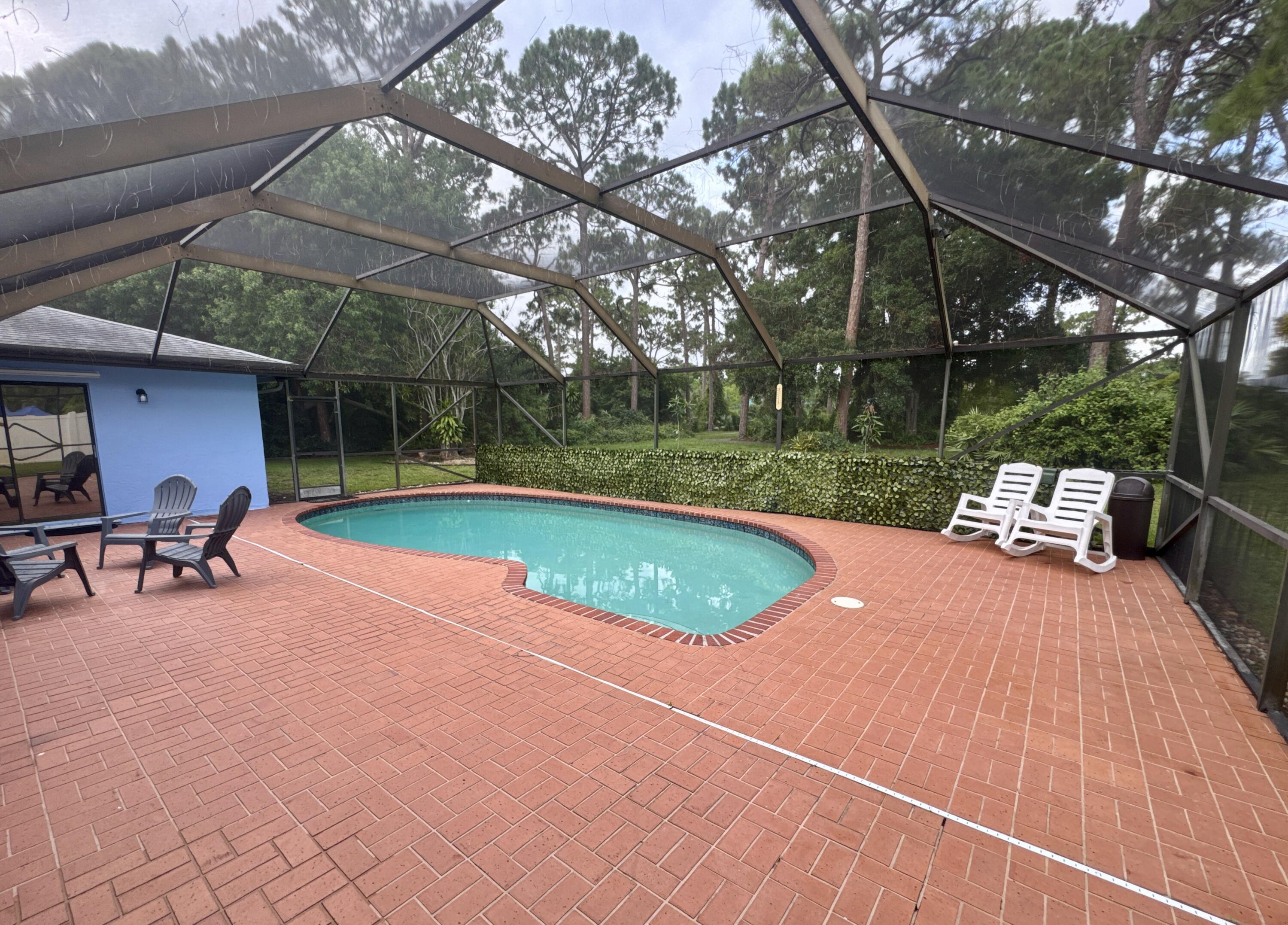 4160 Northwest 7th Court Delray Beach, FL 33445 - Photo 34 of 46 a view of a swimming pool with a patio and a yard