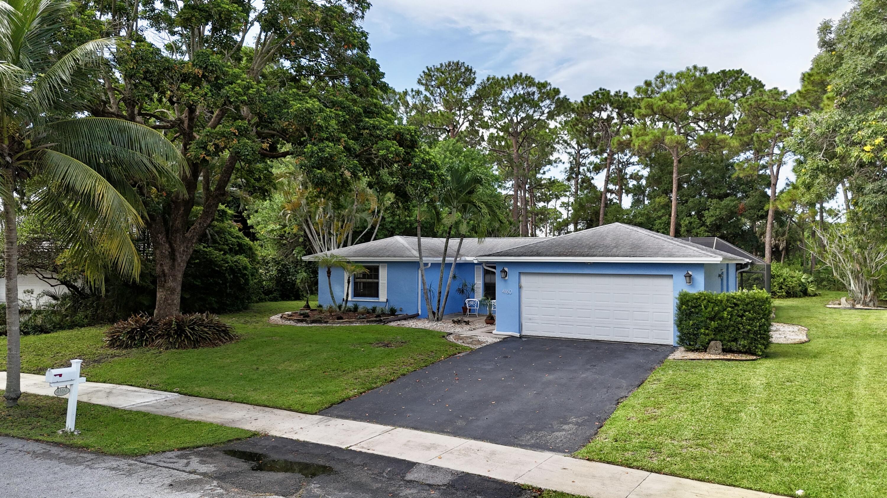 4160 Northwest 7th Court Delray Beach, FL 33445 - Photo 5 of 46 a front view of a house with a yard and trees