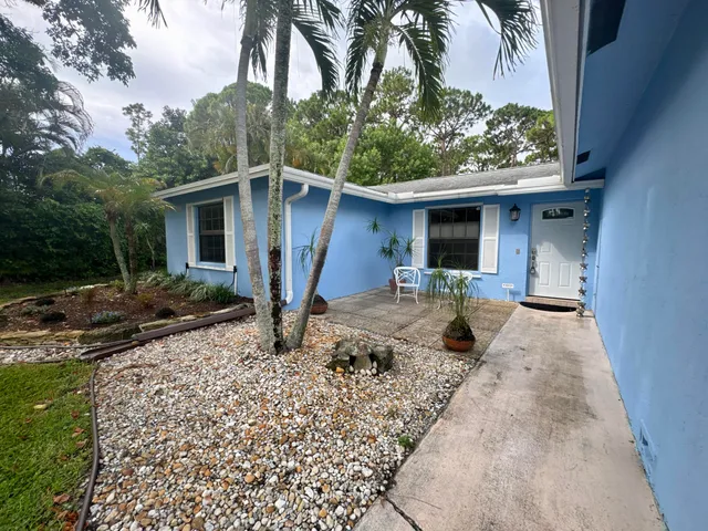a view of a house with backyard and trees