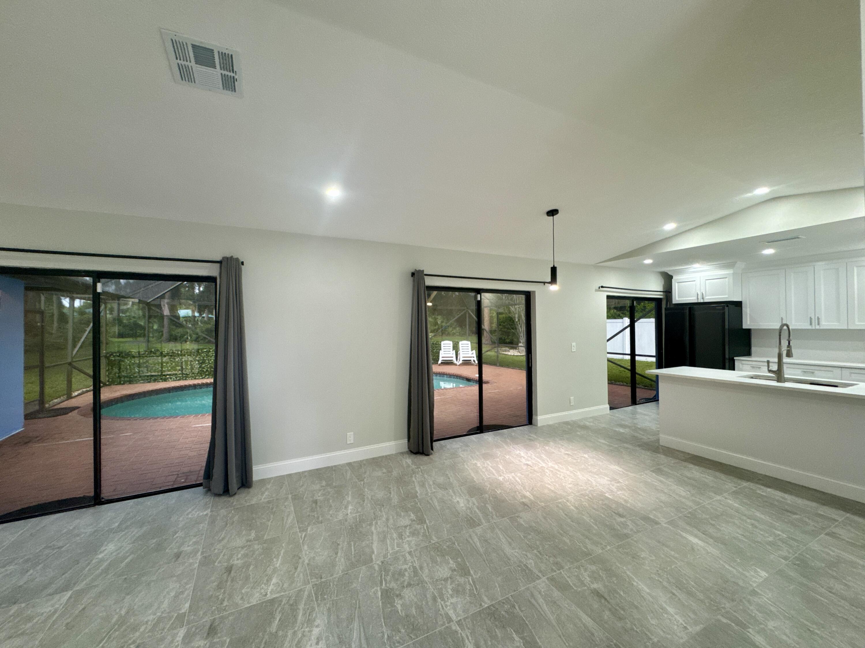 4160 Northwest 7th Court Delray Beach, FL 33445 - Photo 10 of 46 a view of an empty room with kitchen and a window