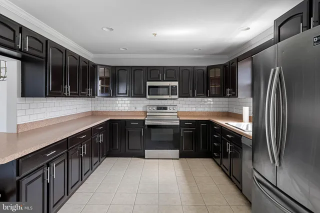a kitchen with stainless steel appliances granite countertop a refrigerator and a stove
