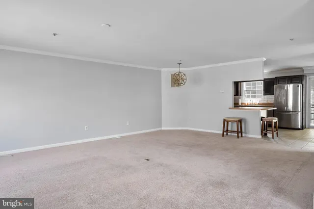 a view of an empty room with windows & cabinet
