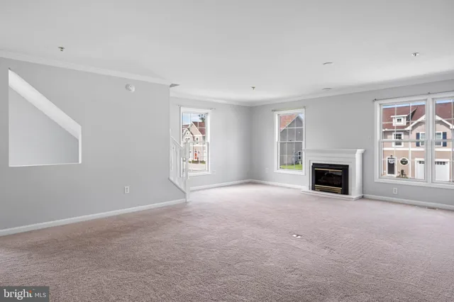a view of a windows and fireplace in an empty room