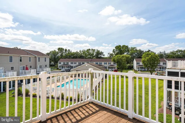 a view of a white house with wooden fence