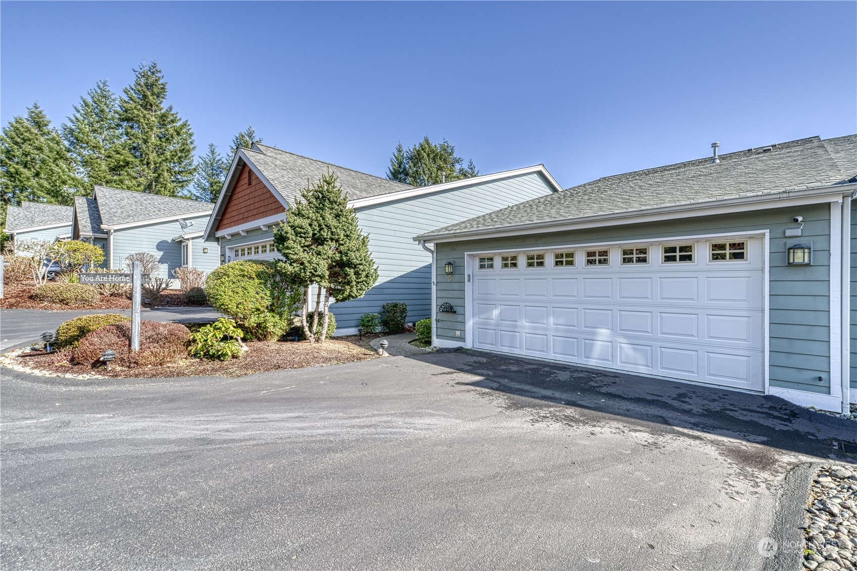 91 East Soderberg Road, Unit B5 Allyn, WA 98524 - Photo 28 of 34 a front view of a house with a yard and garage