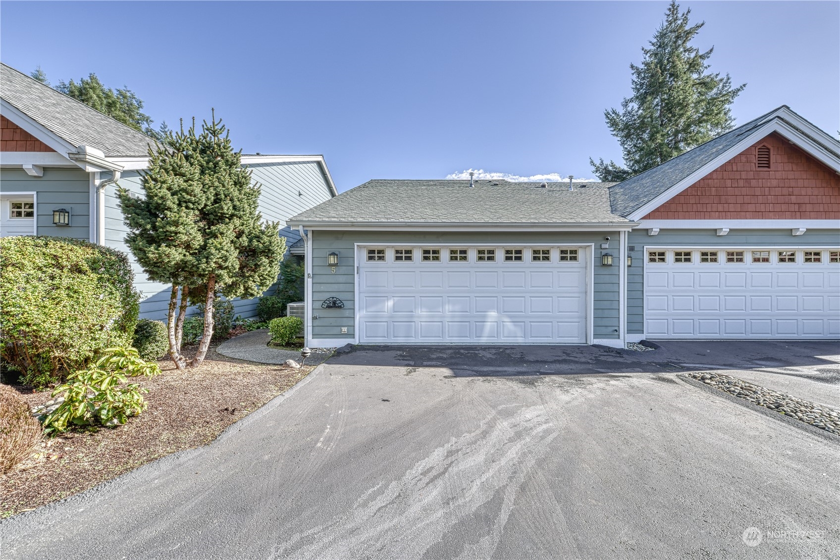 91 East Soderberg Road, Unit B5 Allyn, WA 98524 - Photo 29 of 34 a front view of a house with a yard and garage