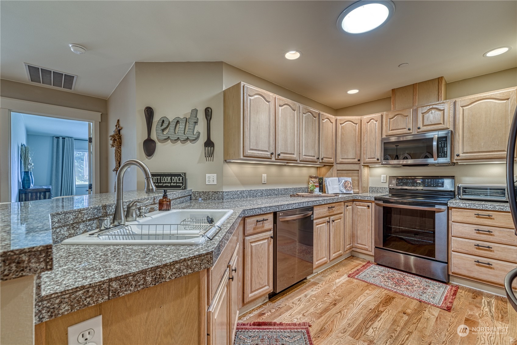 91 East Soderberg Road, Unit B5 Allyn, WA 98524 - Photo 5 of 34 a kitchen with kitchen island granite countertop a sink cabinets and stainless steel appliances