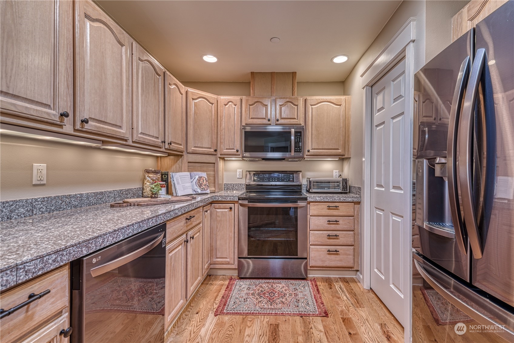 91 East Soderberg Road, Unit B5 Allyn, WA 98524 - Photo 6 of 34 a kitchen with stainless steel appliances granite countertop a refrigerator sink and cabinets