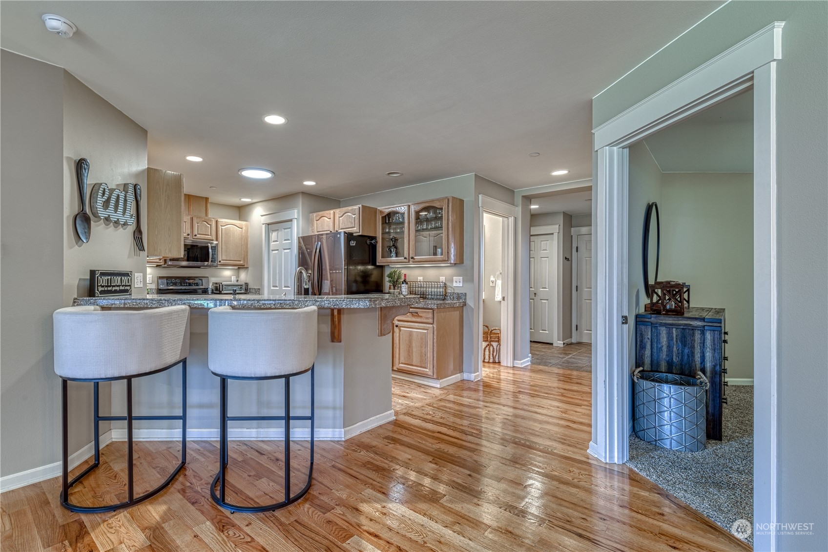 91 East Soderberg Road, Unit B5 Allyn, WA 98524 - Photo 9 of 34 a kitchen with stainless steel appliances kitchen island granite countertop a table chairs and a refrigerator
