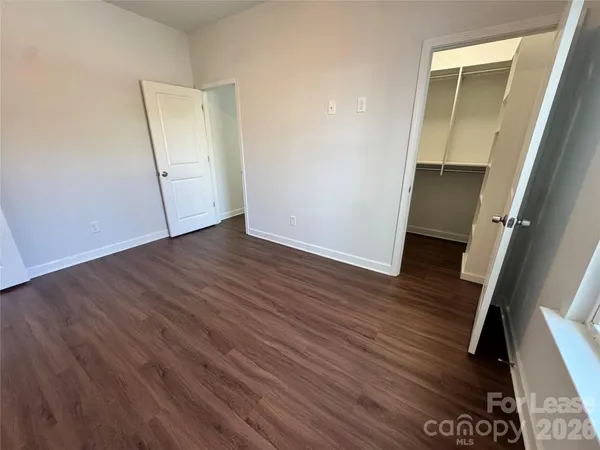 an empty room with wooden floor and glass door