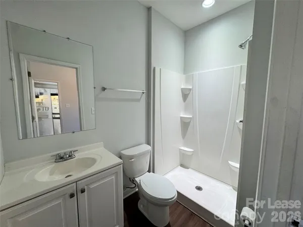 a bathroom with a granite countertop toilet sink and mirror
