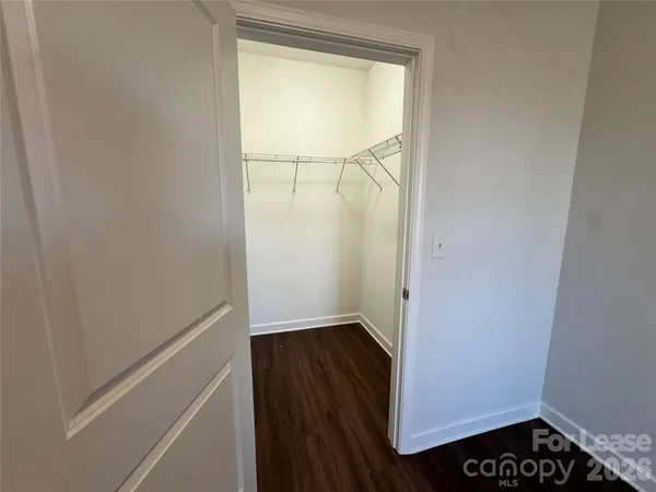 a view of walk in closet with wooden floor