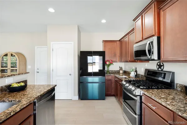 a kitchen with granite countertop stainless steel appliances and wooden cabinets