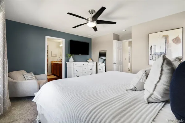 a bedroom with a bed a flat screen tv and a couch