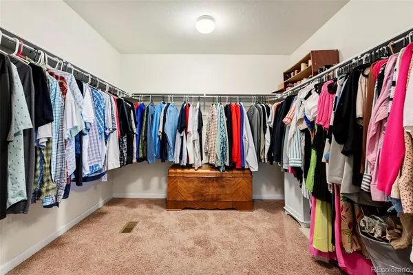 a view of walk in closet with clothes