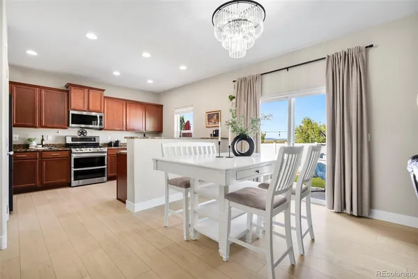 a kitchen with stainless steel appliances a table chairs and a refrigerator