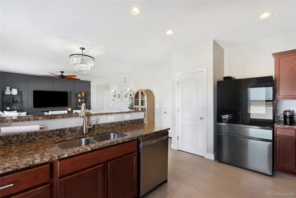 a kitchen with granite countertop a sink and stainless steel appliances