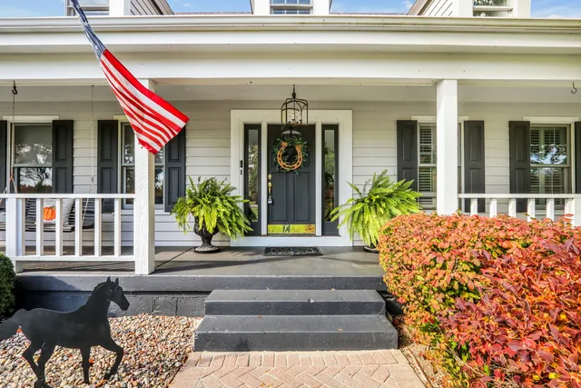 an aerial view of a tennis ground and a cars park side of the road