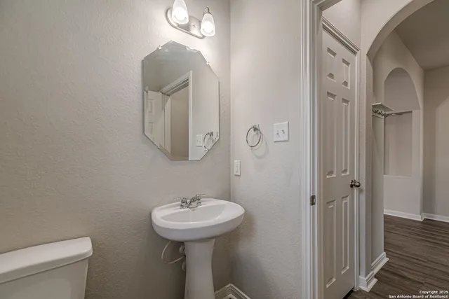 a kitchen with stainless steel appliances granite countertop a stove top oven a refrigerator a sink and dishwasher with wooden floor