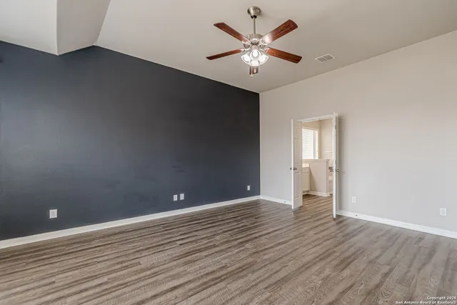 an empty room with wooden floor and empty shelves