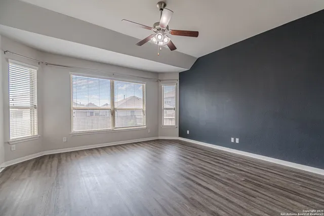 a view of an empty room with wooden floor and cabinet
