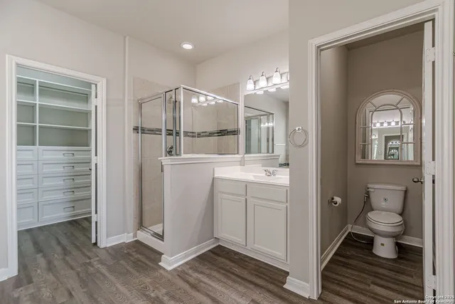 an empty room with a chandelier fan and closet area