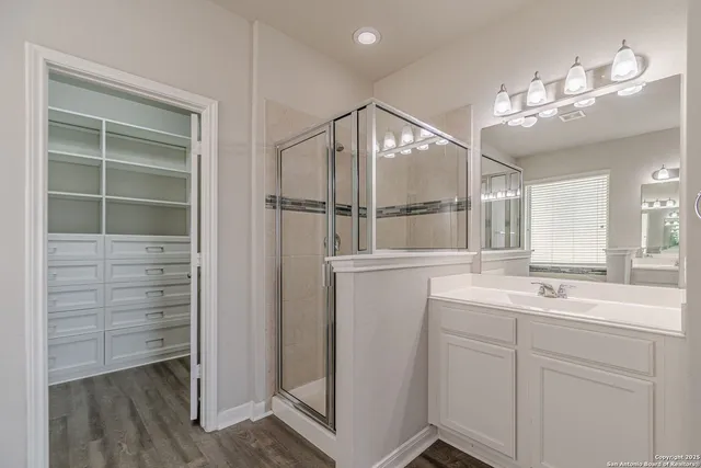 a bathroom with a sink a shower and a mirror