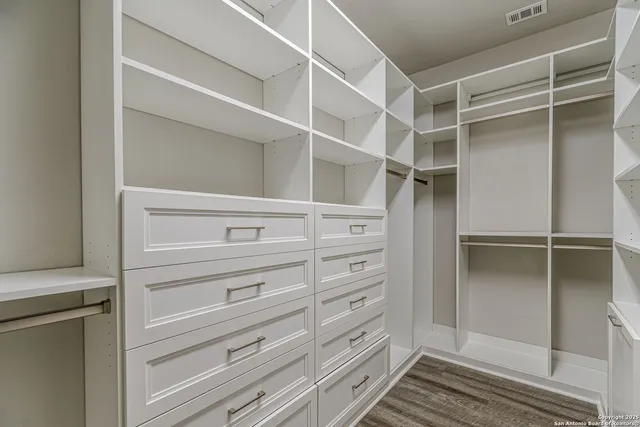 an empty room with closet and fan