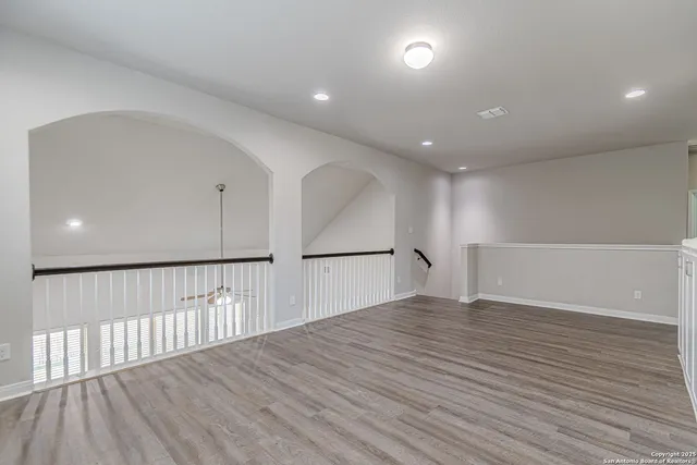 an empty room with a window and a fan