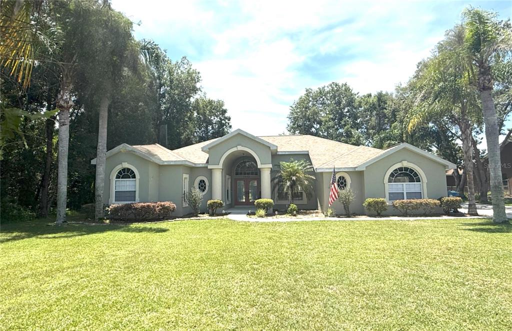 a front view of a house with a yard and trees