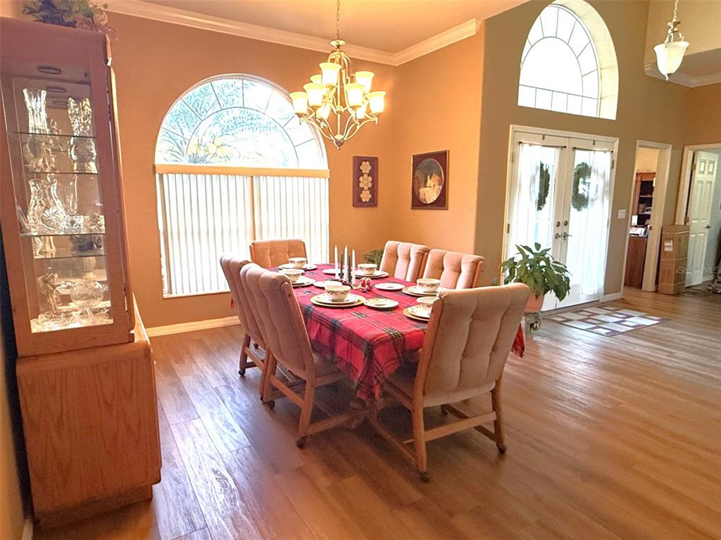 7552 River Country Drive Weeki Wachee, FL 34607 - Photo 15 of 59 a view of a dining room with furniture a chandelier and wooden floor