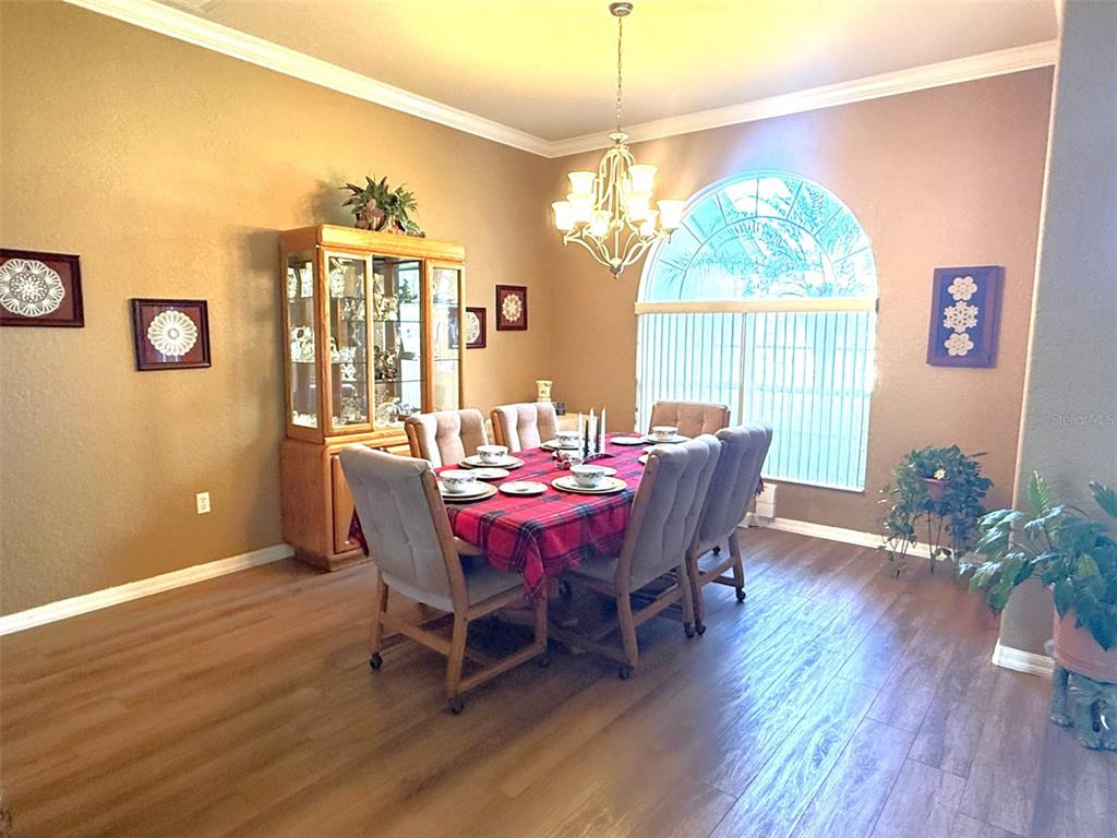 7552 River Country Drive Weeki Wachee, FL 34607 - Photo 16 of 59 a view of a dining room with furniture a chandelier and wooden floor