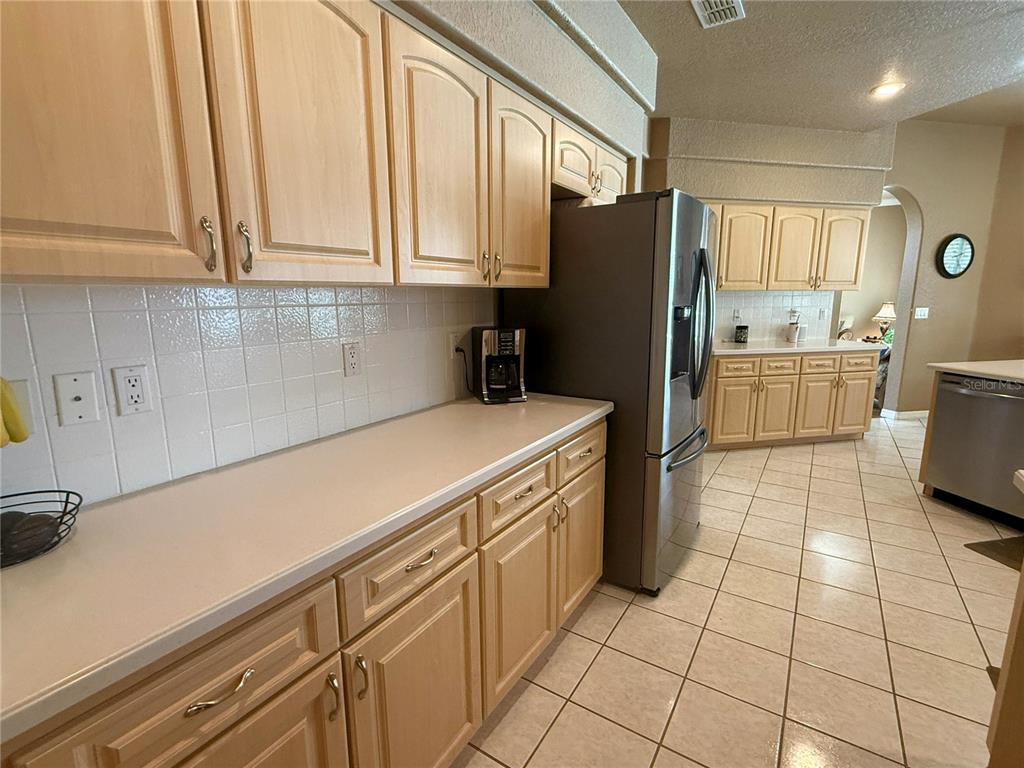 7552 River Country Drive Weeki Wachee, FL 34607 - Photo 23 of 59 a kitchen with a refrigerator a stove a sink and a cabinets