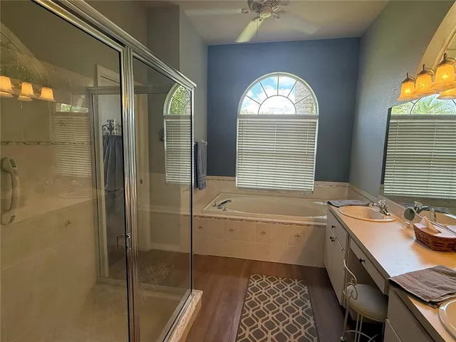 a bathroom with a granite countertop sink mirror and a bathtub