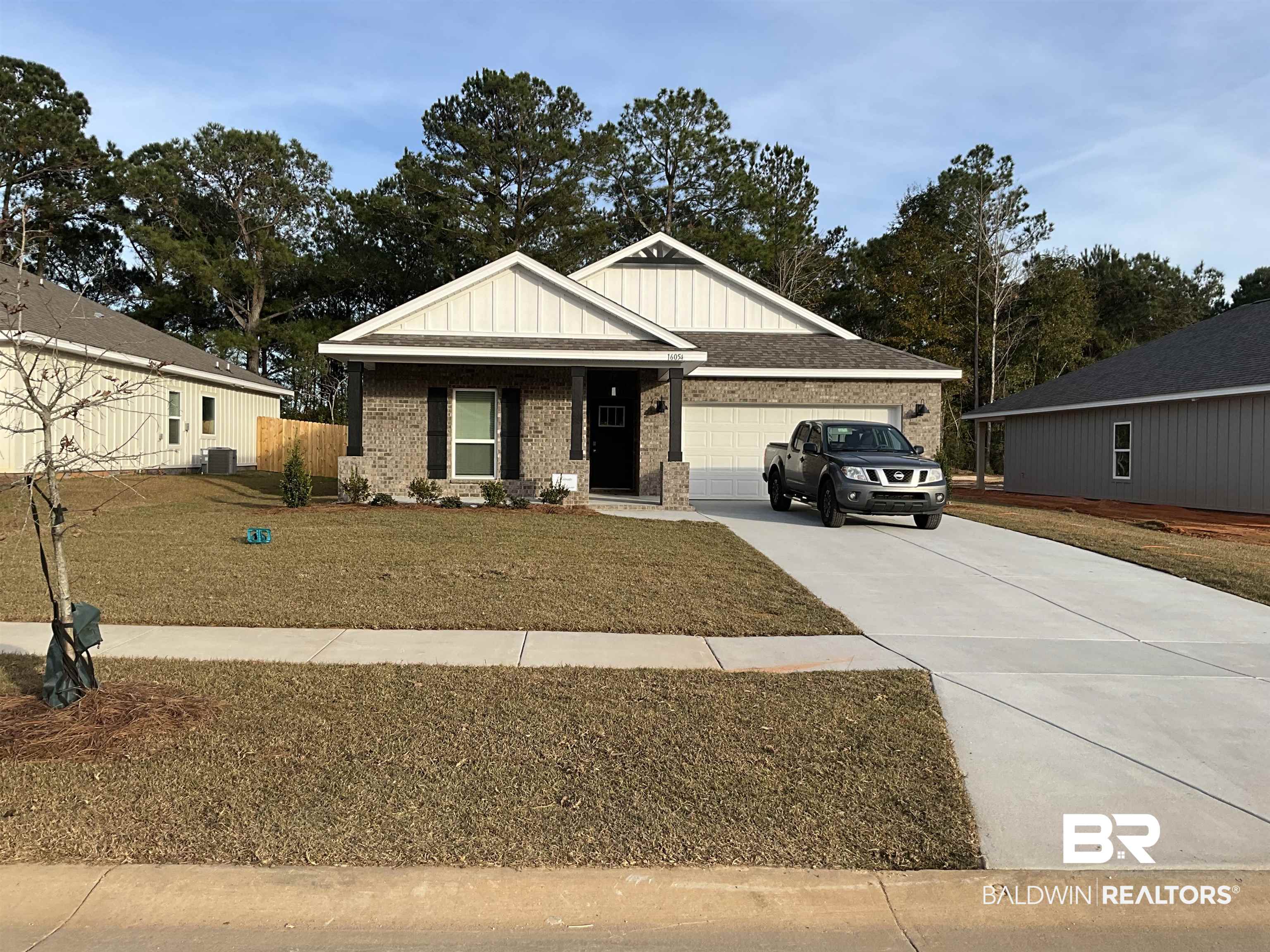 16054 Laurelbrooke Loop Fairhope, AL 36532 - Photo 1 of 38 View of front of house featuring board and batten siding, driveway, an attached garage, brick siding, and a porch